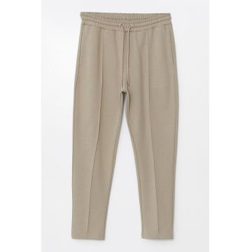 Pantaloni de trening cambrati cu snur de ajustare si model uni